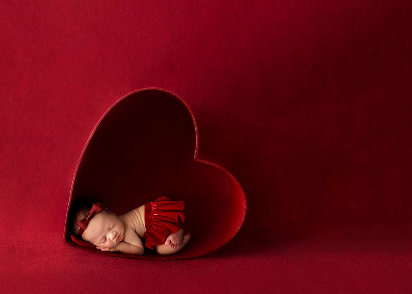 Valentine newborn photography session in heart prop