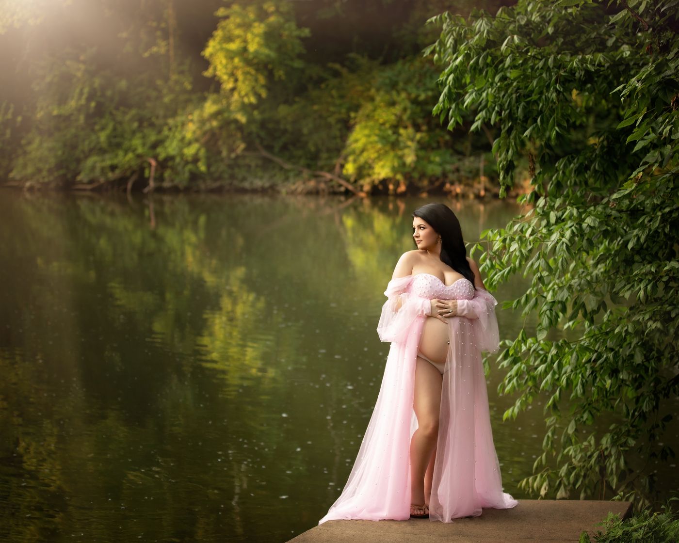 Outdoor maternity photo of pregnant mother in a pink gown by the river in Murfreesboro TN