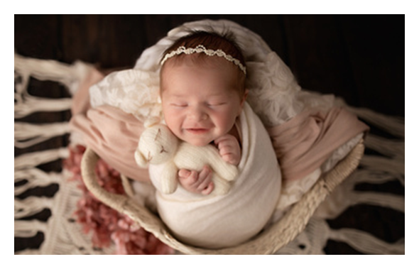 newborn swaddled in clothes in basket