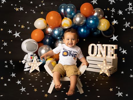 Smiling one-year-old boy celebrating his first birthday in a spaced themed photoshoot with balloons and stars, photographed by Kelly Saxon Photography in Murfreesboro, TN Space Themed First Birthday Photoshoot - Kelly Saxon Photography