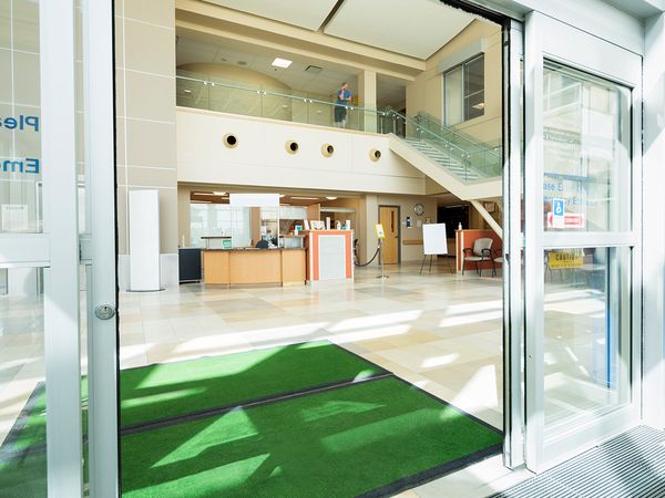 A hospital lobby with clean doormats and floors.