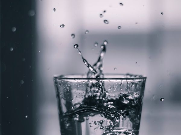 Close up image of splashing water inside of a glass.