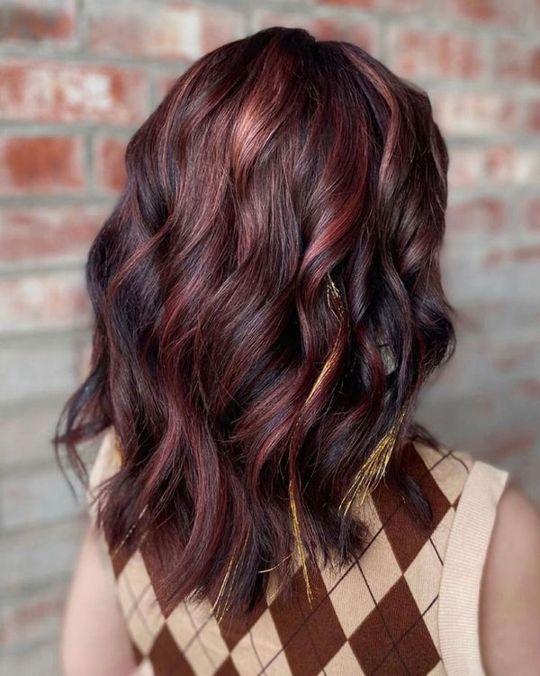 Woman with deep red hair and feathers in her hair