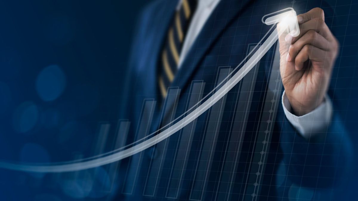 Business man draws virtual arrow showing growth