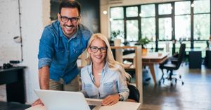 a man and woman smiling while on the computer a man and woman smiling while on the computer
