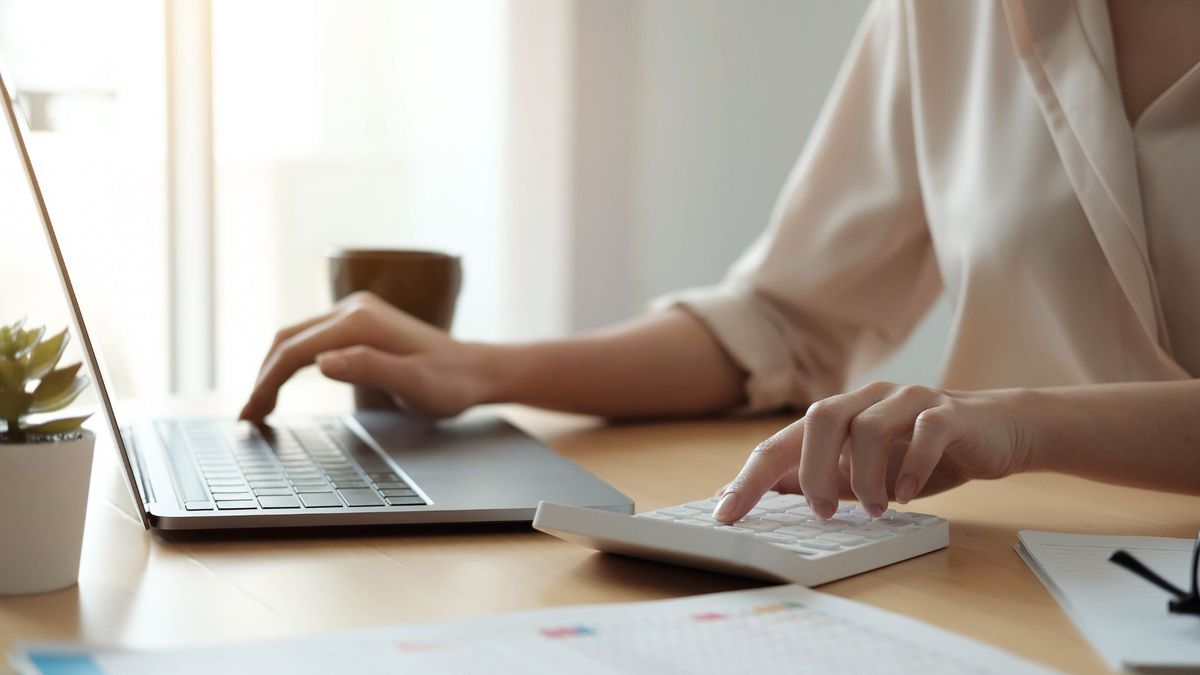 Woman using calculator and laptop