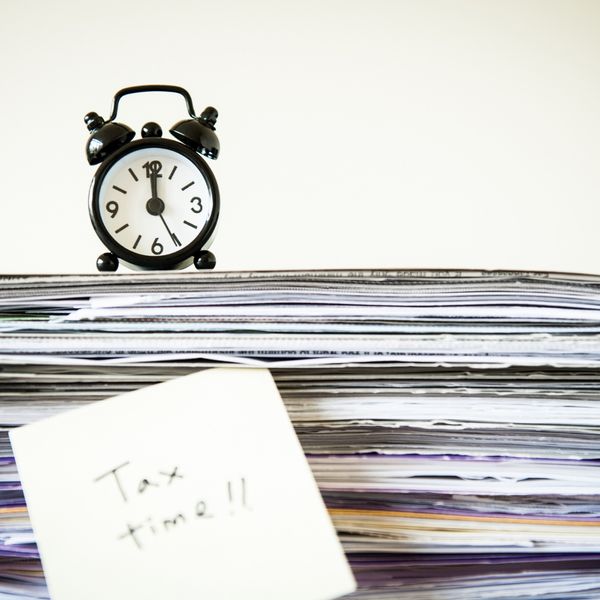 Tax time sticky note stuck to a stack of records