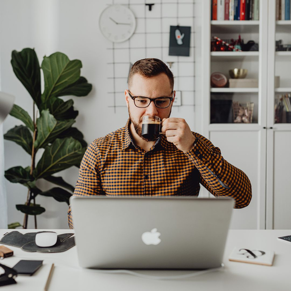 Man sipping coffee in front of his laptop Man sipping coffee in front of his laptop