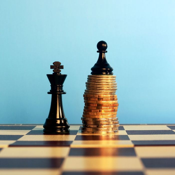 queen next to a pawn stacked on a pile of money