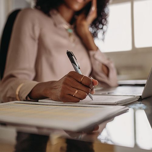 Woman taking notes while on the phone