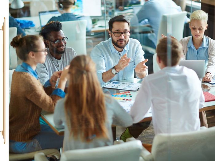 Group of coworkers sitting at a table in an office