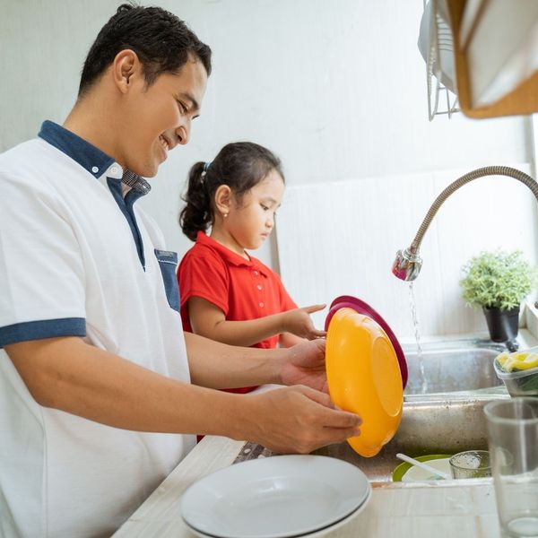 father and daughter cleaning dishes