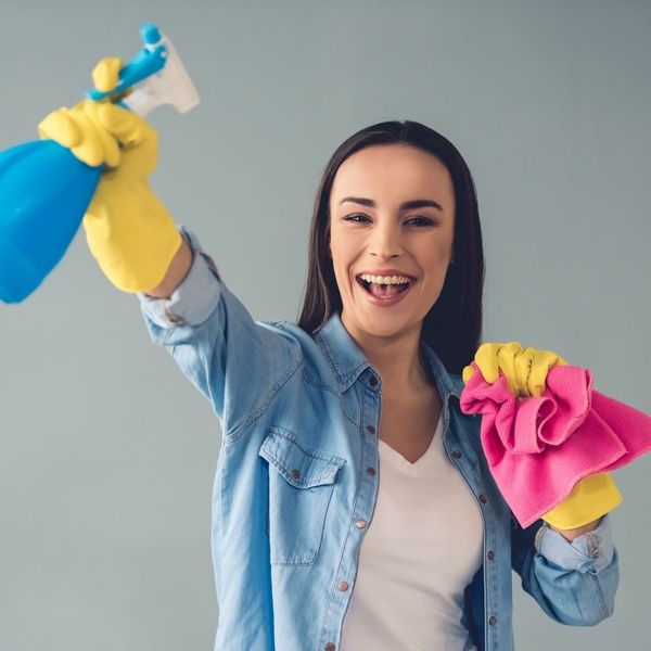 happy woman with spray bottle and dust cloth