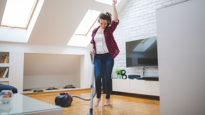 Woman vacuuming with headphones on