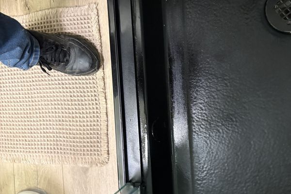 Employee looking at a shower drain