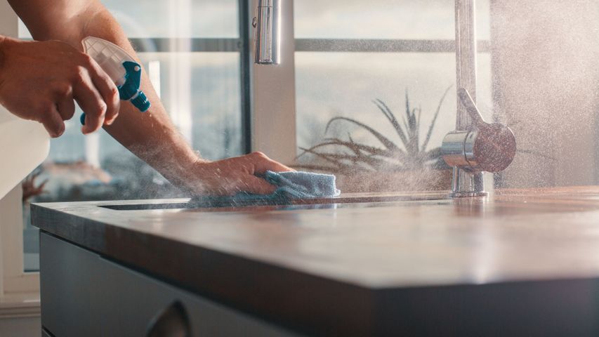 man cleaning kitchen countertop