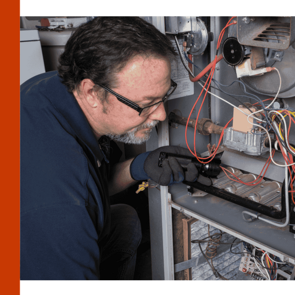 Image of a worker fixing a furnace Image of a worker fixing a furnace