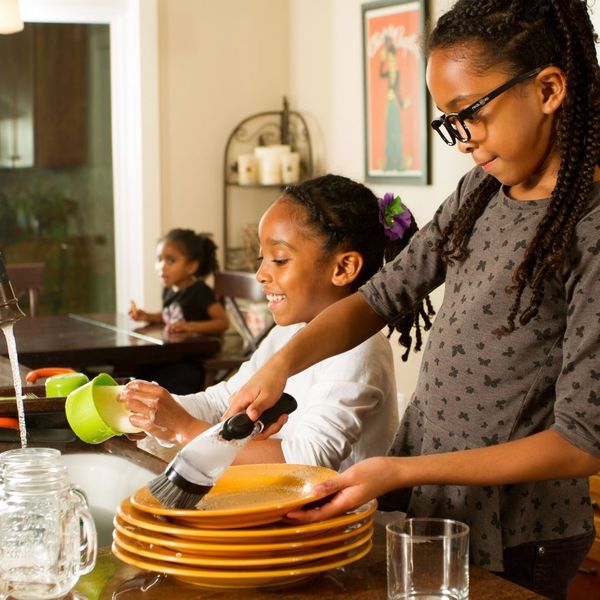 two young girls do dishes