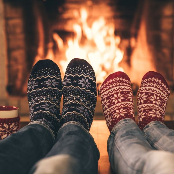 people warming their feet by a fire