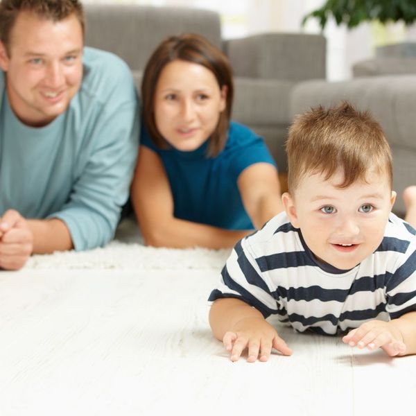 parents watching child play on carpet 