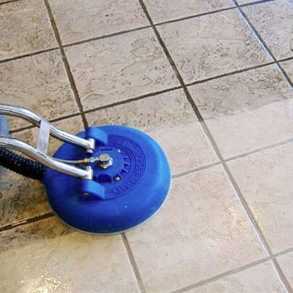 close up of someone cleaning dirty tile grout on floor