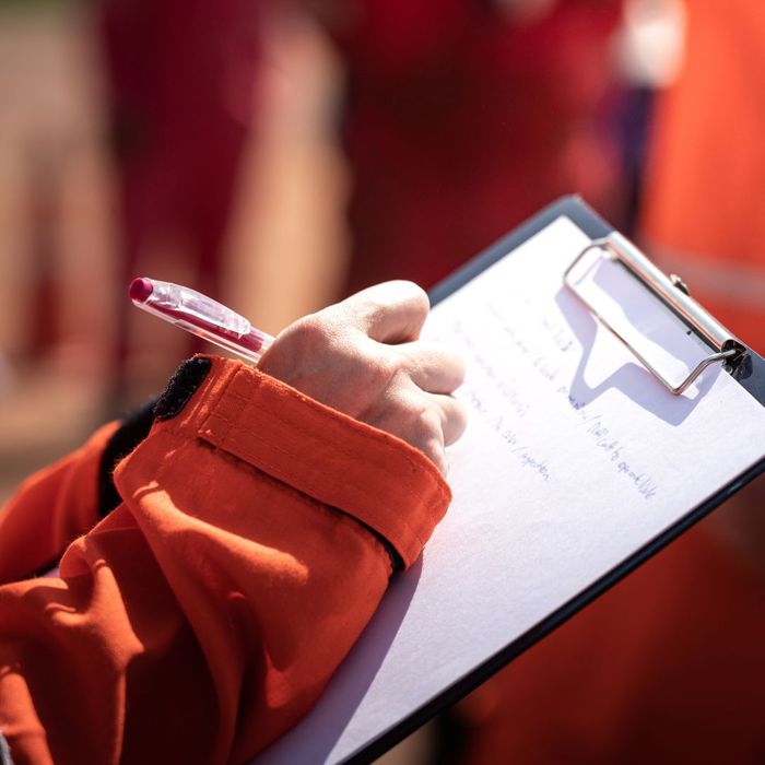 person writes on clipboard