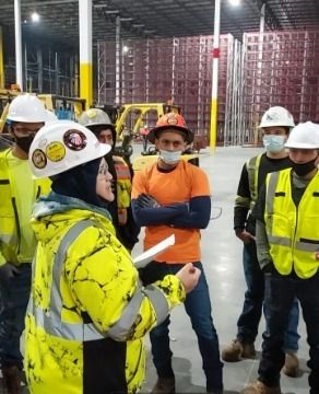 A group of construction workers in a warehouse