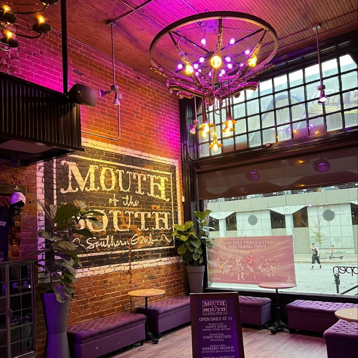Mouth of the South location with purple lights and exposed brick interior