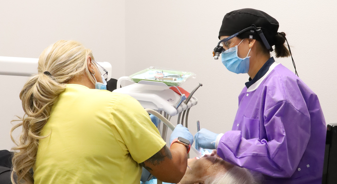 dentist and dental assistant work on patient