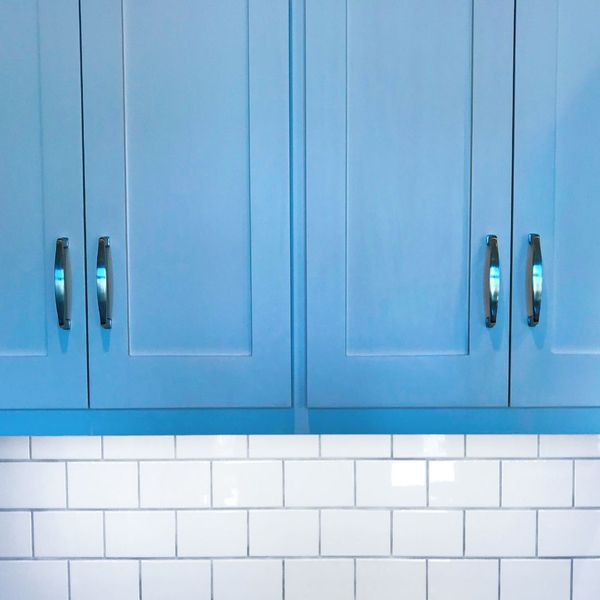 Bright blue cabinets against a white backsplash.