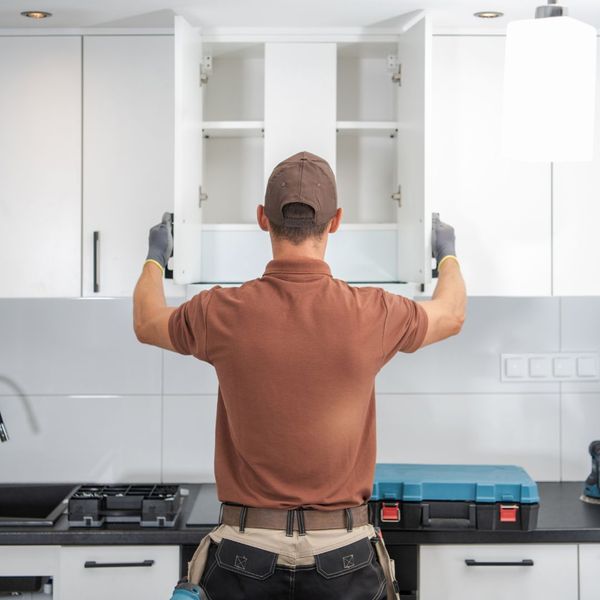 man installing cabinets