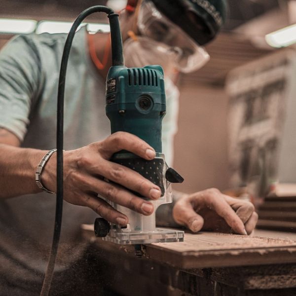 Carpenter using a surfacing tool to make a cabinet
