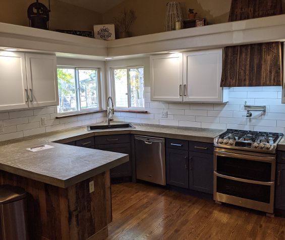 Kitchen with Gray bottom cabinets, white uppers, and wood accents