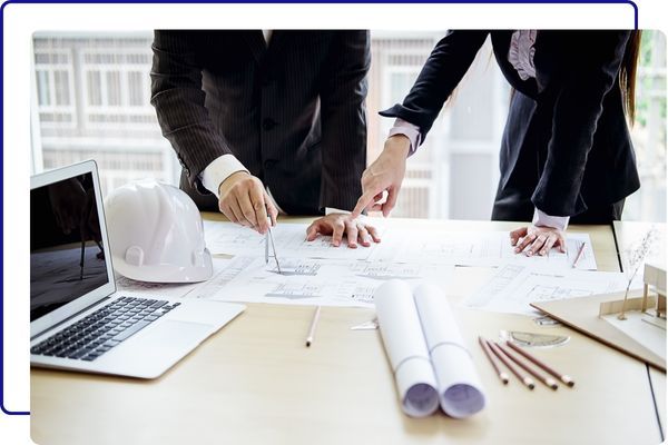 Two people looking over blueprints Two people looking over blueprints