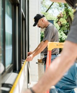 a contractor measuring windows