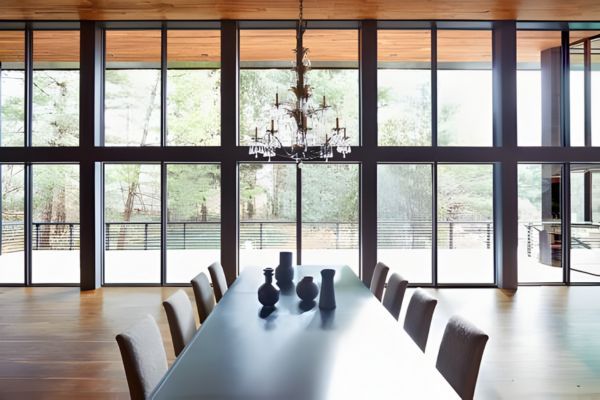 a modern interior space with a long dining table and chandelier