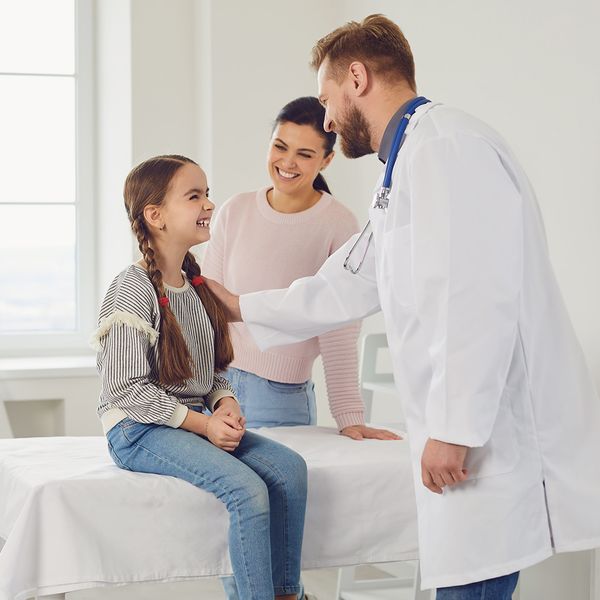 A girl and her mother visiting with a doctor