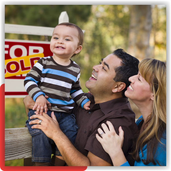 Family in front of a for sale sign