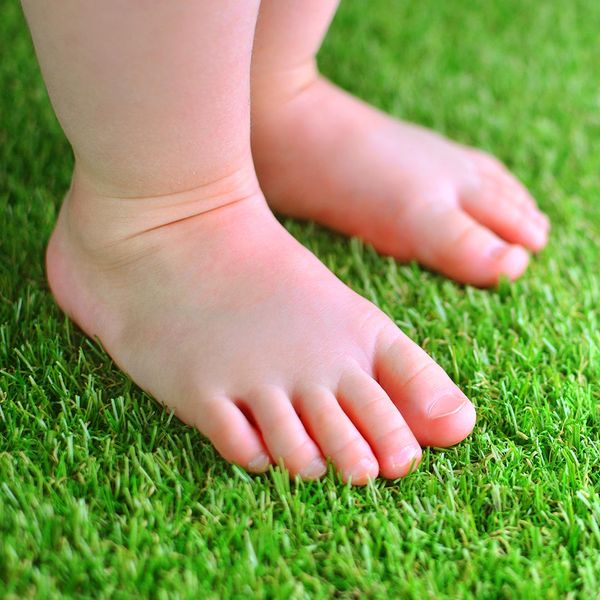 baby standing on turf lawn