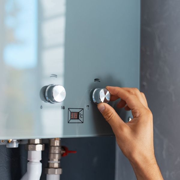 a knob being turned on a water heater