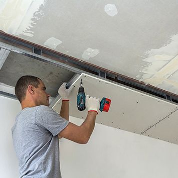 A man installing drywall
