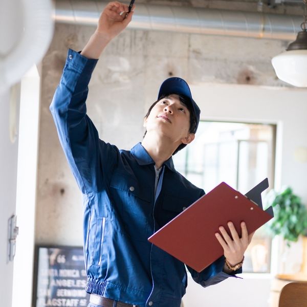 A person's hand changing a lightbulb in a modern ceiling fixture, representing minor home maintenance.