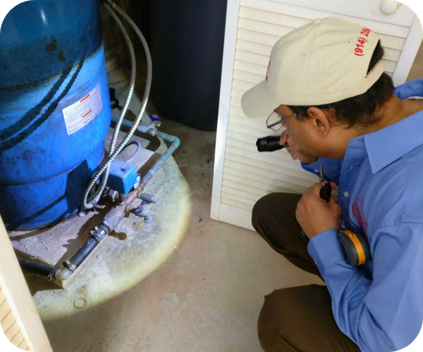 Inspector with a flashlight examining a water heater or pressure tank in a basement or utility area. Inspector with a flashlight examining a water heater or pressure tank in a basement or utility area.