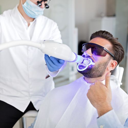 dentist whitening man's teeth