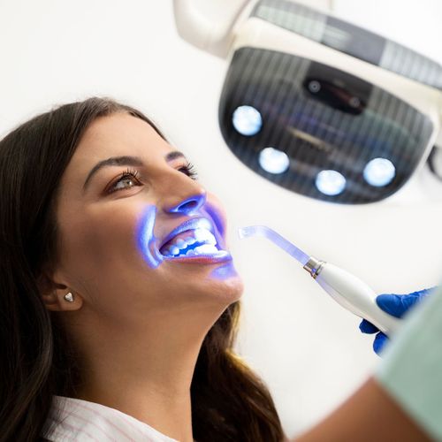 dentist whitening woman's teeth