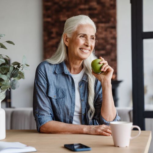 smiling woman eating apple