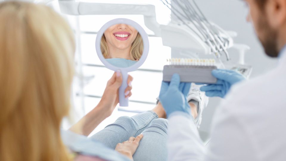 woman and dentist looking at teeth whitening colors