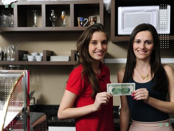 Small business owners holidng their first dollar.