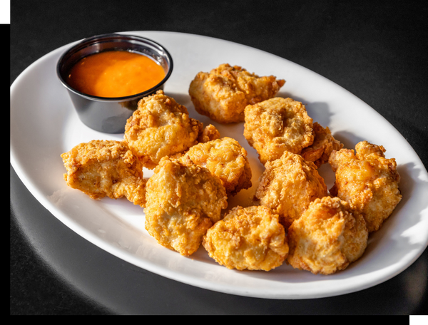a plate of boneless wings with a dipping sauce