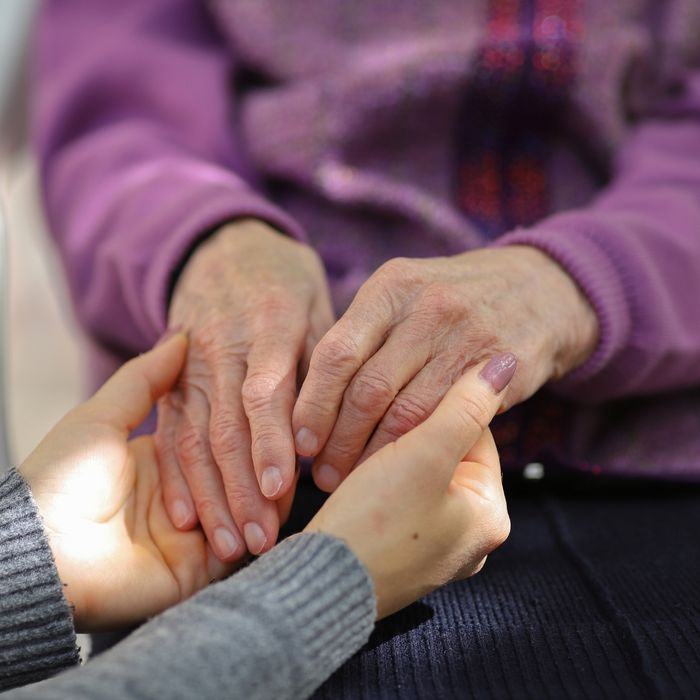 elderly person holding hands with younger person